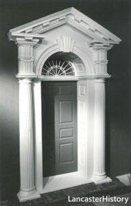 A fancy wooden doorframe with columns and a pediment.