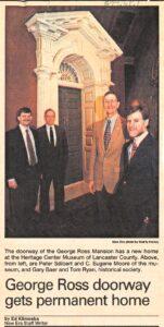 Several men standing in front of an ornate doorframe.