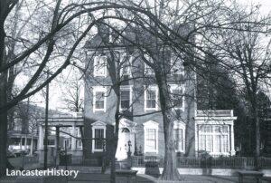 Three story brick home with roof dormers.