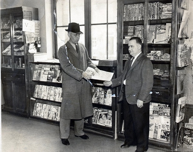 Willie Siple with a customer in his news stand