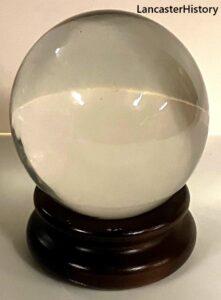 Round glass ball on a wooden stand
