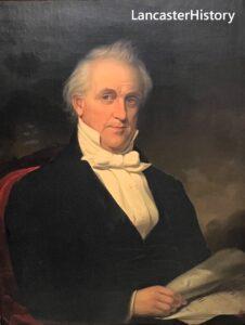 Portrait of man sitting from waist up, wearing black suit and white bow tie