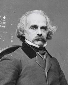 Image of a seated man from waist up with bushy mustache.