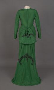 Image of a green silk dress with black jeweled embroidery.