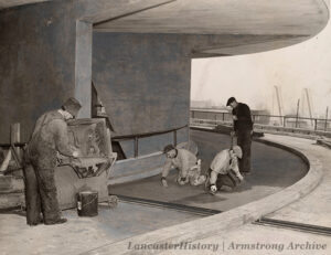 Workmen apply the finish coat to the Monocork surface of "The Road of Tomorrow." Photo: LancasterHistory, Armstrong Archive.