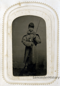 A young Civil War solider poses with his gun, bayonet affixed, and a pipe dangling from his mouth. (c. 1860s)