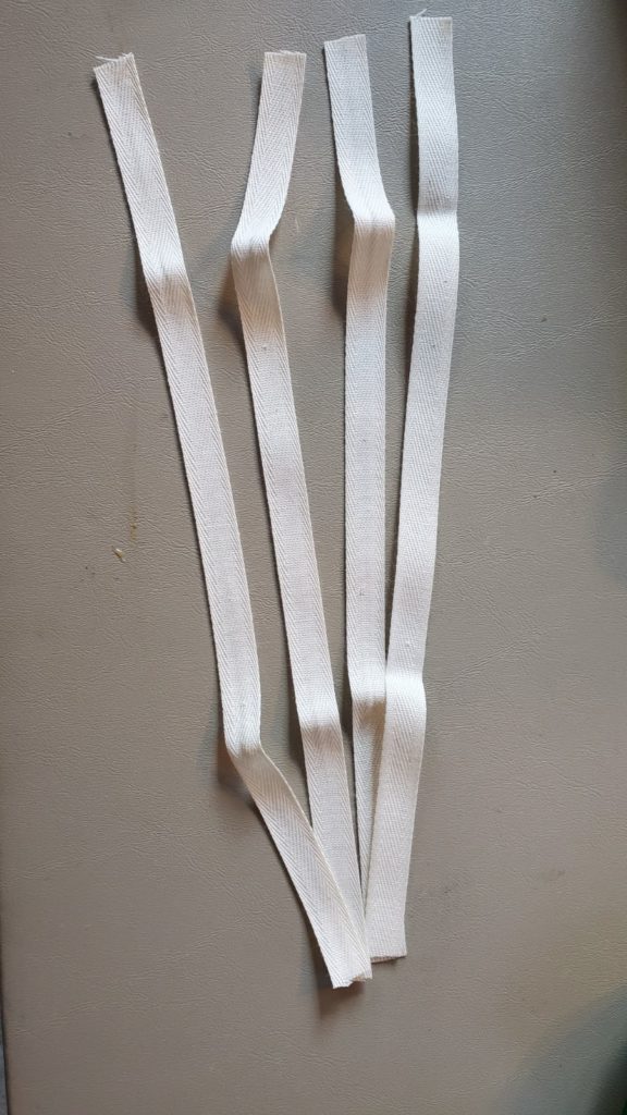 Four cotton tape ties cut to 12 inches