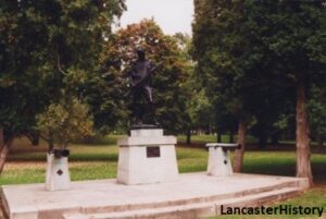 Statue of a soldier holding a rifle flanked by a cannon on either side.