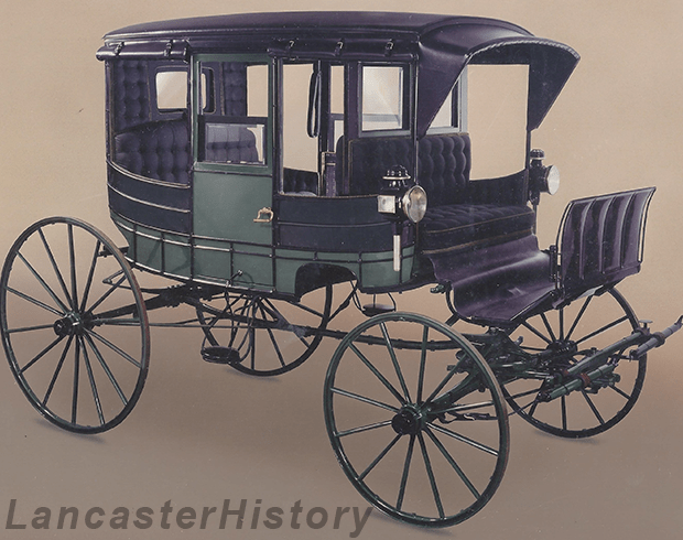 A black and green colored carriage with four large wheels.