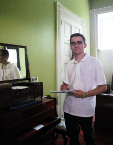 A young student stands in the bedroom of Buck Henry at Wheatland.