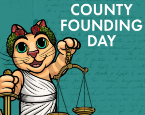 An illustration of a cat wearing a toga next to text "County Founding Day."