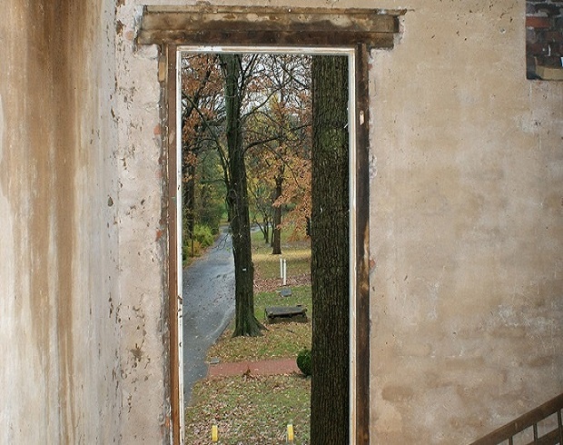 Photograph of the interior of the smokehouse looking out through the smokehouse door.