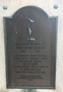 Brass plaque with an image of a baseball hitter and words