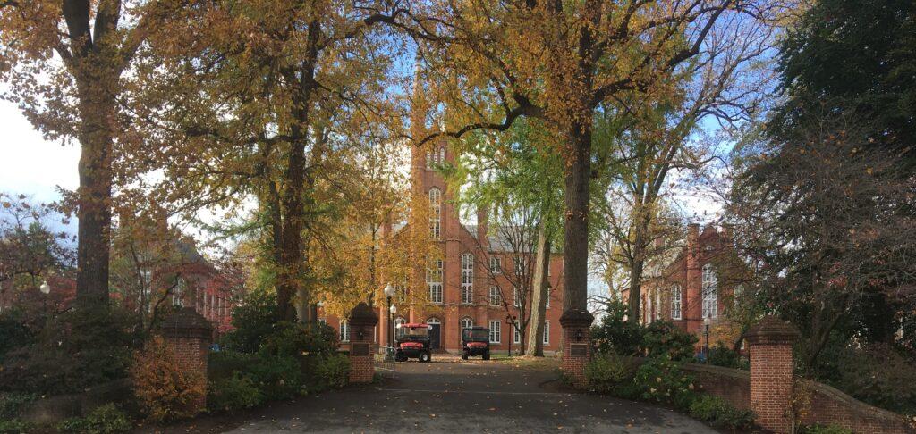 Color photograph of the main entrance to F&M showing brick columns on either side of a driveway