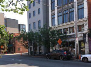 Street scene showing a large building and adjacent alley.