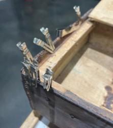 Leather attached to wooden case with clamps.