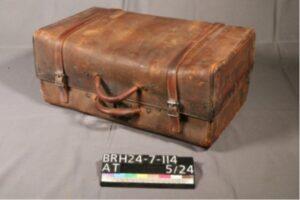 Leather case with two handles and straps.