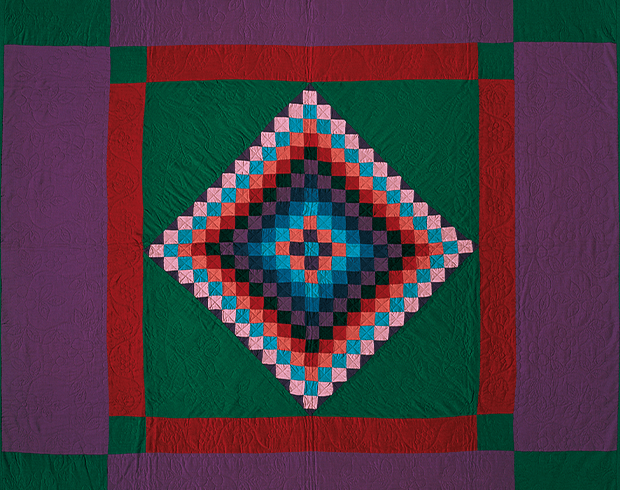 Photograph of a colorful quilt with multicolor squares forming a diamond within a square.