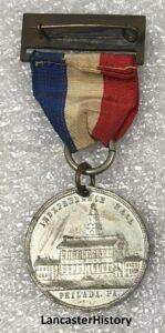 A souvenir medallion with a red, white, and blue ribbon