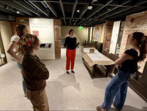 Standing students listening to an adult instructor