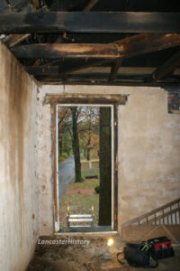 Photograph of a view through the smokehouse door from the interior