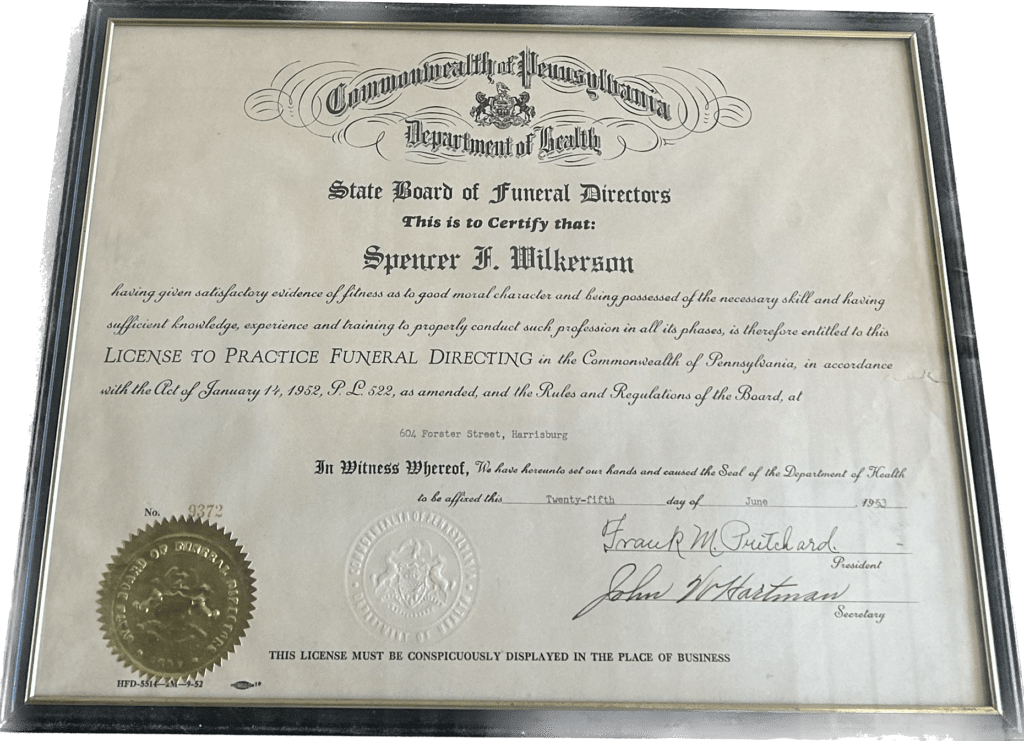 A paper certificate in a glass frame. Prominently featured is the Commonwealth of Pennsylvania seal at the top, center, and another gold foil seal at the bottom left. 