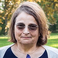 An image of Louise Stevenson, an older woman with light skin with short brown hair and glasses.