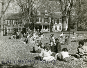 A black and white photo of the Wheatland lawn with many children sitting in the grass.