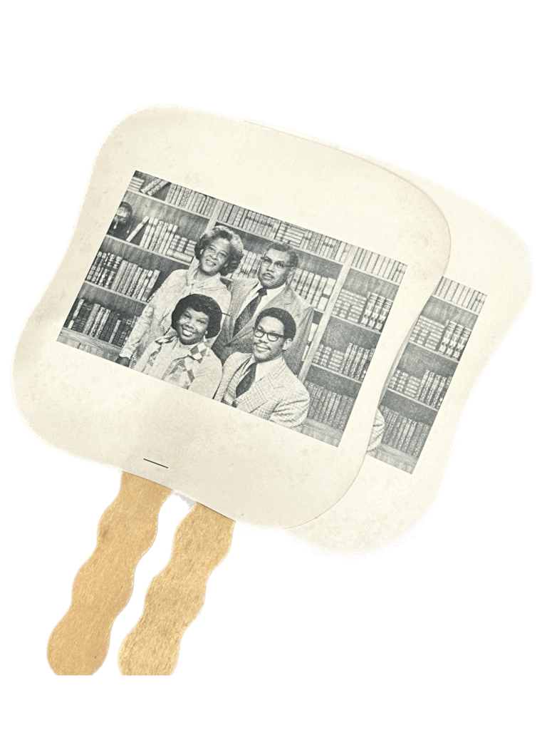 Two handheld fans. The handle is made of a thin wood in a wavy pattern. The fan is a stiff paper stapled to the end of the wood. On the fan is a black and white image of two Black women and two Black men in formal wear in front of a bookcase.