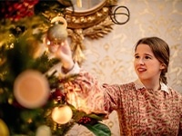 Image of young woman decorating tree.