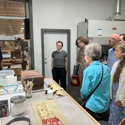Group of people looking at objects on a table.