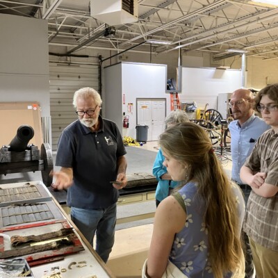 Group of people looking at wooden objects.