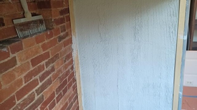 Detail shot of a scratch coat applied to an interior wall of the firebox.