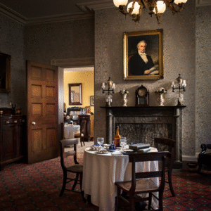 The Parlor A perspective view of the parlor looking in to the dining room. Light is focused on a portrait of James Buchanan above the mantle.