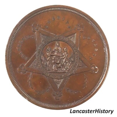 <i> Commemorative coin front, GAR Department of Pennsylvania Annual Encampment, Lancaster, 1884. LancasterHistory, Gift of Civil War Museum of Philadelphia. </i> Cooper coin with GAR symbol in center.