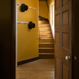 The Domestic Servants' Stairs A perspective viewing the winding servant's staircase and wall hooks with two top hats.